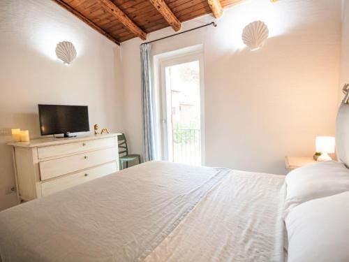 a bedroom with a white bed and a television at Apartment Palau by Interhome in Arzachena