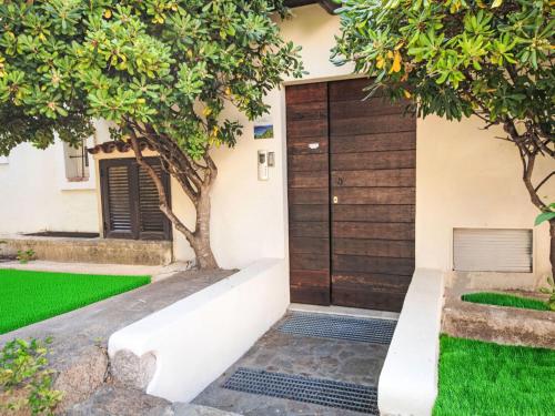 a house with a gate and green grass at Apartment Palau by Interhome in Arzachena
