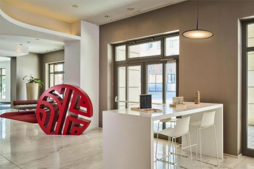 a kitchen with a red chair in a room at NH Collection Nürnberg City in Nürnberg