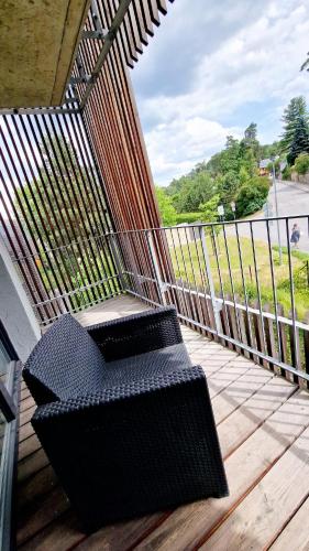 a black bench sitting on a wooden deck at Lakepark Residence in Staré Splavy