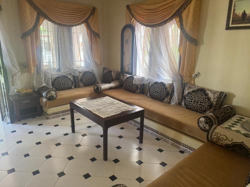 a living room with a couch and two windows at Plage Alamine Fnideq Tamuda bay in Fnidek