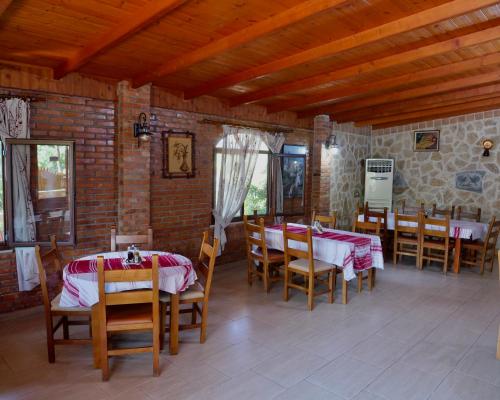 a dining room with tables and chairs in a house at Sofra e Vjeter Restaurant and Guesthouse in Bregu i Lumit
