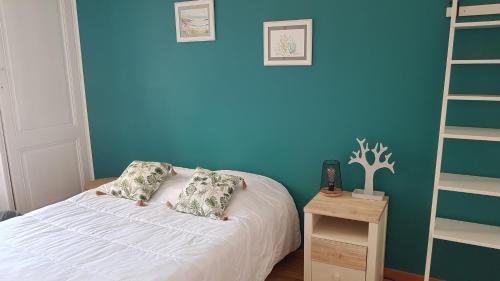 - une chambre avec un lit blanc et un mur bleu dans l'établissement Appartement 4 personnes 50m2 à 300m de la plage, à Berck-sur-Mer