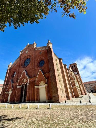 a large brick church with a blue sky in the background at Attico del Duomo Historic Center & Free Wi-Fi in Asti