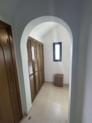 a hallway with an archway and wooden doors at Villa Eden Djerba in Djerba