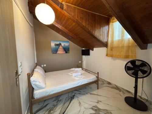 a bedroom with a bed and a window and a fan at HELEN STUDIOS Loft in Plános
