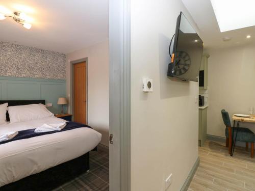 ein Schlafzimmer mit einem Bett und einem Fernseher an der Wand in der Unterkunft Cosy Cottage 5 in Durham