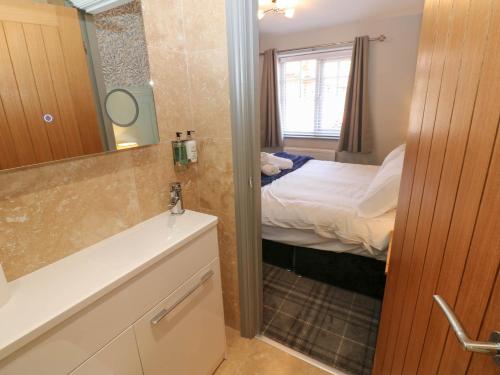 ein kleines Bad mit einem Bett und einem Spiegel in der Unterkunft Cosy Cottage 5 in Durham