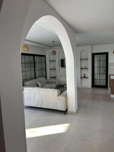 a living room with a white couch and an archway at Villa Eden Djerba in Djerba