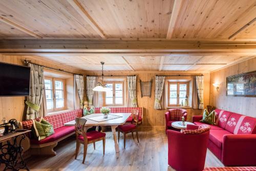 Una sala de estar con sofás rojos y una mesa. en Residenz 111, en Holzgau