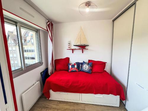- une chambre avec un lit rouge et une fenêtre dans l'établissement Apartment Les Normandières-24 by Interhome, à Cabourg