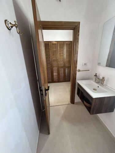 a bathroom with a sink and a mirror and a door at Villa Eden Djerba in Djerba