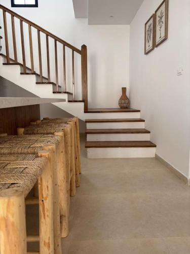a room with a row of wooden benches and stairs at Villa Eden Djerba in Djerba