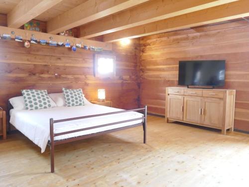 a bedroom with a bed and a flat screen tv at Holiday Home Rustico Bel Panorama by Interhome in Malvaglia