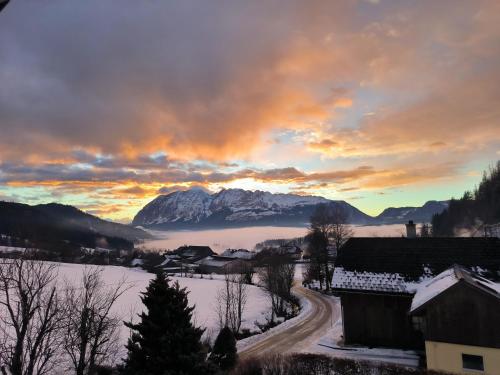 a winter sunset over a town with snow covered mountains at Der SteinStadL in Raumberg