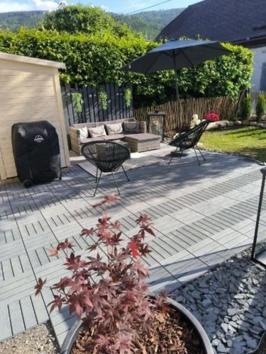 a patio with two chairs and an umbrella at Der SteinStadL in Raumberg