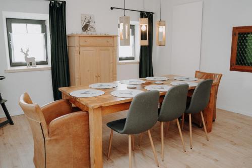 a dining room with a wooden table and chairs at Der SteinStadL in Raumberg