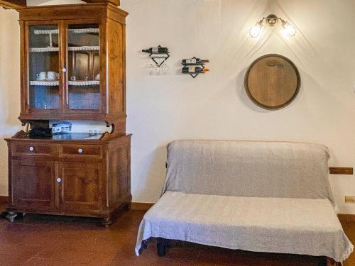 a bedroom with a wooden cabinet and a bench and a mirror at Agriturismo Tenuta Badia in Paciano