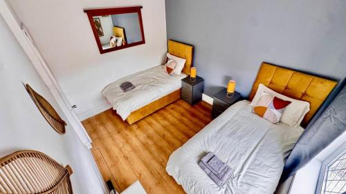 a small room with two beds and a mirror at Luxury 5-Bed Home in Nicholson, Close to Sheffield City Centre, Jacuzzi, BBQ, Parking & Wi-Fi, Sleeps 10 in Heeley