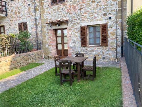 a wooden table and chairs in front of a building at Agriturismo Tenuta Badia in Paciano