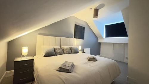a bedroom with a large white bed with a window at Luxury 5-Bed Home in Nicholson, Close to Sheffield City Centre, Jacuzzi, BBQ, Parking & Wi-Fi, Sleeps 10 in Heeley