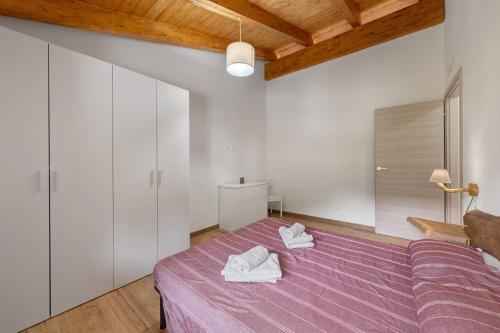 a bedroom with a purple bed with two towels on it at Agriturismo Le Macere in Sasseta