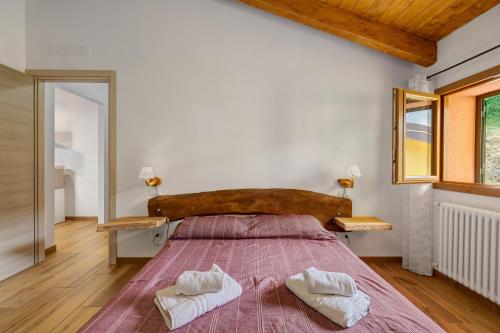 a bedroom with a large bed with two towels on it at Agriturismo Le Macere in Sasseta