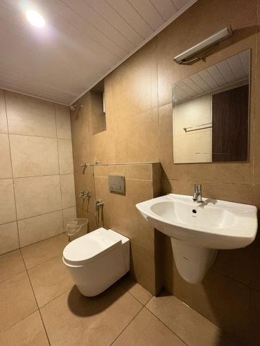 a bathroom with a white toilet and a sink at Crystal inn BY D2V in Kakkanad