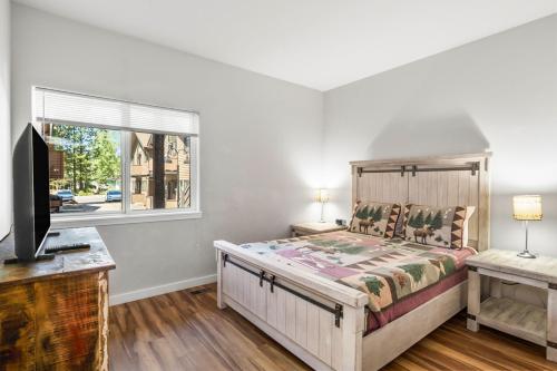 a bedroom with a bed and a tv and a window at Woodpecker Lookout in Sunriver