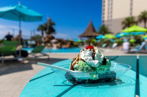 a bowl of ice cream on a table near a pool at Holiday Inn Resort Pensacola Beach Gulf Front by IHG in Pensacola Beach