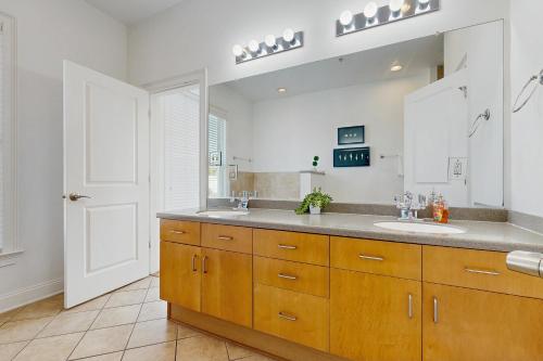 a bathroom with two sinks and a large mirror at Contemporary Home in Perfect Location - 207 B St Philip Street in Charleston
