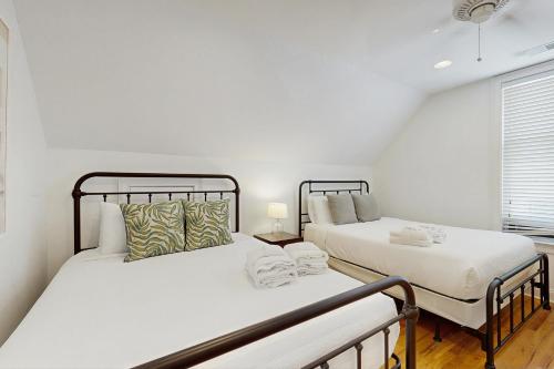 two beds in a white room with a window at Contemporary Home in Perfect Location - 207 B St Philip Street in Charleston