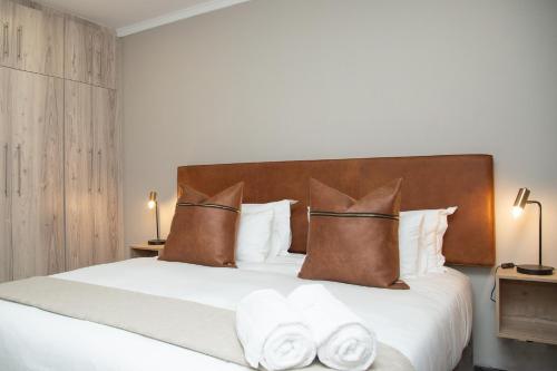 a bedroom with a large bed with white sheets and pillows at Summer PALACE Guesthouse in Bloemfontein