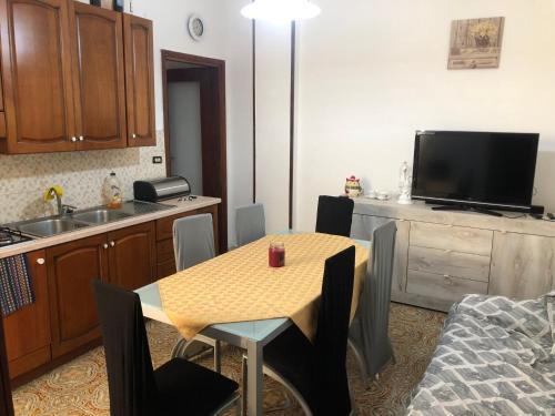 a kitchen with a table with chairs and a television at Gallipoli lido San Giovanni via savonarola 37F in Gallipoli