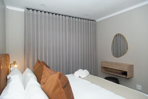 a hotel room with a bed and a window at Summer PALACE Guesthouse in Bloemfontein