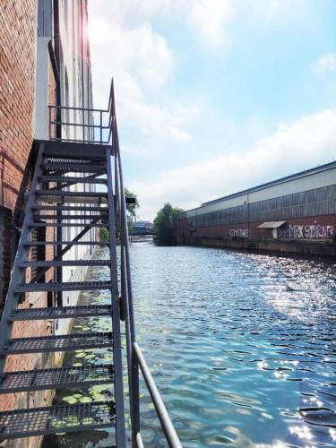 a staircase leading down to a river next to a building at Stay - you time in Hamburg
