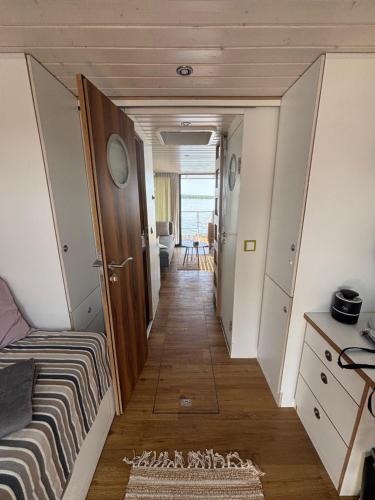 a hallway leading to a room with a bed and a hallway at WOHLFÜHLBOOT Hausboot - Festlieger in der Marina Zaue am Schwielochsee - incl Stand Up Board in Schwielochsee