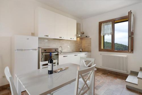a kitchen with a table with a bottle of wine on it at Agriturismo Le Macere in Sasseta