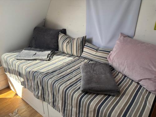 a bed in a room with two pillows on it at WOHLFÜHLBOOT Hausboot - Festlieger in der Marina Zaue am Schwielochsee - incl Stand Up Board in Schwielochsee