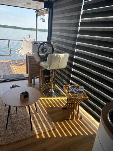 a deck on a boat with a table and chairs at WOHLFÜHLBOOT Hausboot - Festlieger in der Marina Zaue am Schwielochsee - incl Stand Up Board in Schwielochsee
