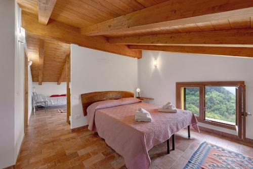 a bedroom with a bed in a room with wooden ceilings at Agriturismo Le Macere in Sasseta