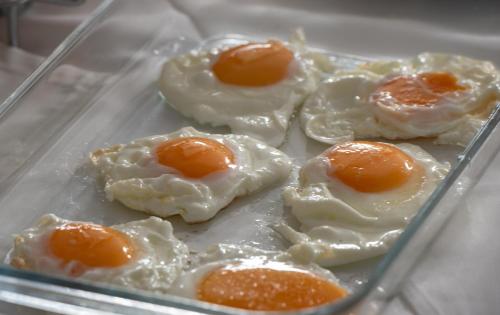 a glass container filled with fried eggs on a table at Light Blue Hotel in Nea Kalikratia