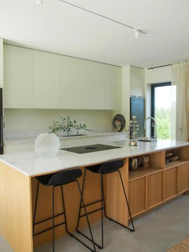a kitchen with a large island with two bar stools at Architect-Designed House With Meadow Views in Vårgårda