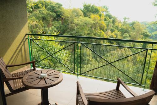 a balcony with two chairs and a table and a view at Iguazu Jungle Lodge in Puerto Iguazú
