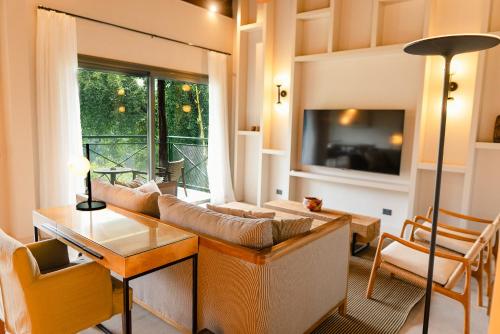 a living room with a couch and a tv at Iguazu Jungle Lodge in Puerto Iguazú