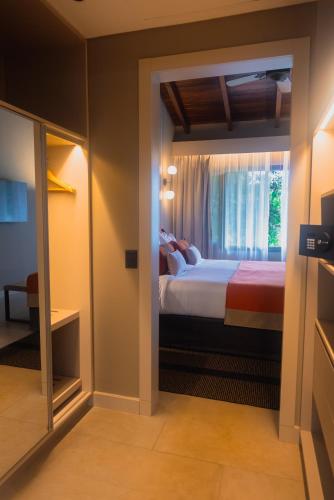a hotel room with a bed and a window at Iguazu Jungle Lodge in Puerto Iguazú