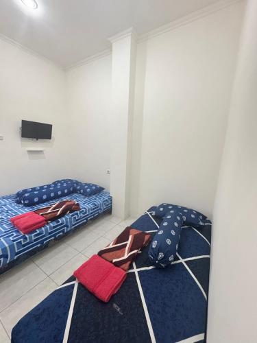 a room with two beds and a tv on the wall at SATU Hotel by Taslim Gading Serpong in Tangerang