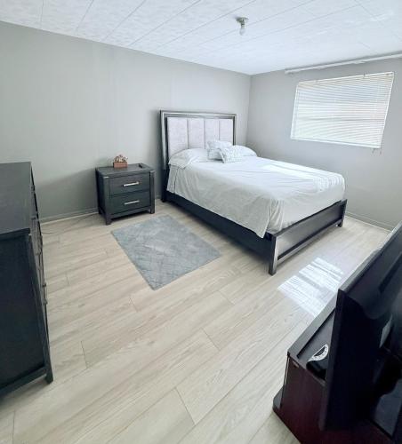 a bedroom with a bed and a television in it at Riviera Haven, 10 Minutes from the Beach, Coastal Town, Quaint & Comfy in Riviera Beach