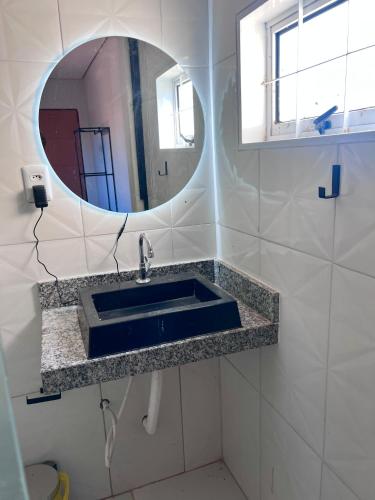 a bathroom with a sink and a mirror at Suíte aconchegante no coração da Cidade in Sidrolândia