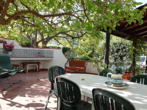 un patio avec une table et des chaises sous un arbre dans l'établissement Scopello Villa Sole, à Scopello